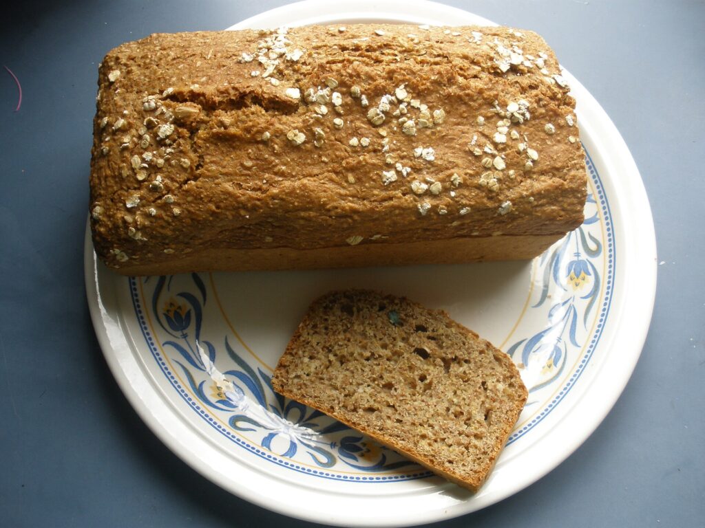 Sliced brown soda bread with coarse salt on white decorative plate