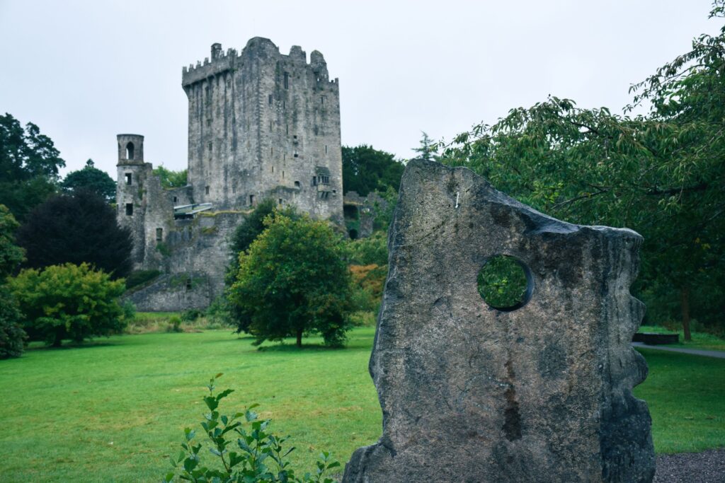 Medieval stone castle tower with circular window ruin in foreground