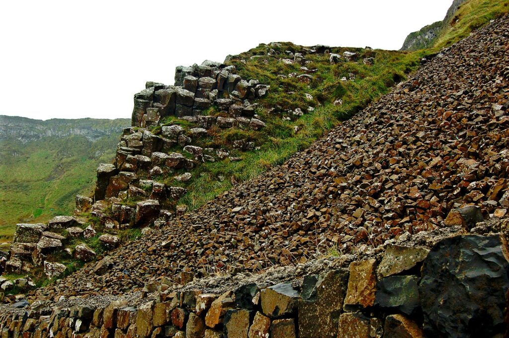 Moss-covered stone walls and scree slope on Irish hillside
