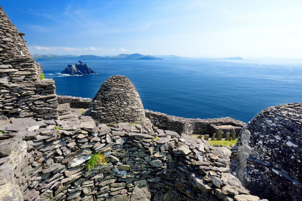 Ancient stone ruins overlook blue ocean with distant islands and mountains