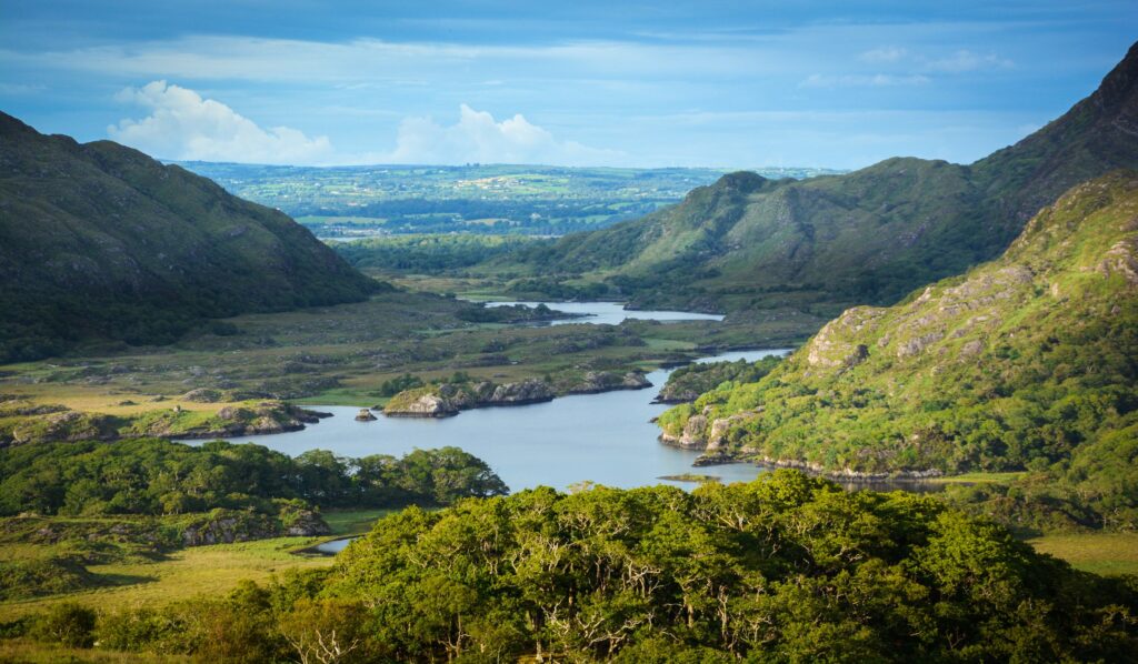 Mountain valley with multiple blue lakes surrounded by green hills and vegetation