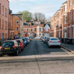 Cars line the street in a european town